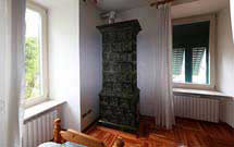 Stufa verde scuro verticale in ambiente classico con pavimento in legno 2